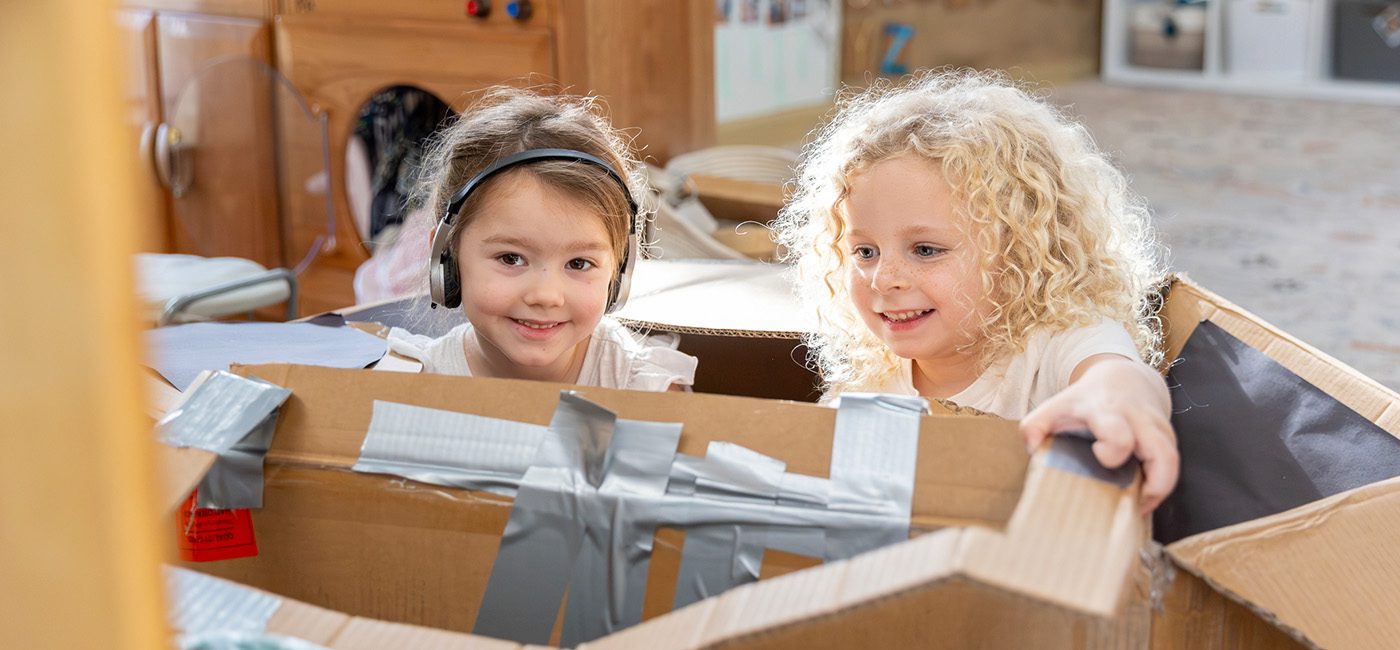 Children exploring a cardboard box at the Preschool for Creative Learning